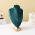 Silver snowflake pendant necklace displayed on dark green velvet bust stand with wood base - Dark Green Velvet Large