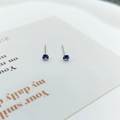 Detalle de los pendientes de plata S925 con circonitas púrpuras y engaste de cuatro garras - Morado