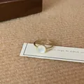 Detailed macro view of an adjustable gold-toned flower ring with a round opal gemstone - Round Cat-eye Look Open Ring (JZ0605)
