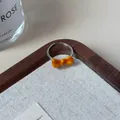 Adjustable silver ring featuring a glossy orange resin bow detail on a white cushion - Orange Yellow Bowknot Open Ring