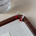 Silver open ring featuring four red beads on a minimalist double-line cross band - Red Twisted Intertwined Open Ring