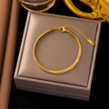 Détail du fermoir mousqueton réglable et du poinçon K18 sur un bracelet chaîne serpent doré - 【e101】bracelet À Chaîne Fouet D'équitation Or