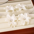 Detail view of elegant white pearl-luster petal earrings with crystal centers in box - Ivory White Petal Style (E1462-2/Silver Needle)