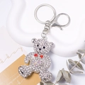 Sparkling rhinestone teddy bear keychain with red bow and heart charm on silver base - Silver