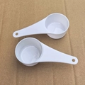 Two pieces of white plastic measuring spoons with long handles for kitchen use - White