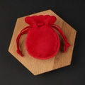 Small red velvet jewelry pouch with wavy edges and drawstring on a wooden tray - 7*9cm / Red