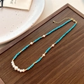 Dettaglio di perle turchesi con perle d'acqua dolce su vassoio in legno scuro - Collana Con Più Perle d Acqua Dolce
