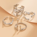 Vista macro de anillos plateados estilo lava con diseño de metal líquido y acabado espejo - Set Lava Deconstructivismo / Plata Brillante