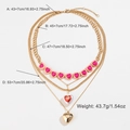 Four-layer gold tiered necklace featuring pink enamel hearts and polished charms - Four Layered Heart Necklace (DNXN04706)
