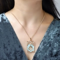 Detail of vintage gold tarot pendant with blue enamel sun design on a female model - Light Blue Sun Pattern (NXN06314)