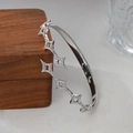 Primer plano del brazalete de plata con estrellas de circonita sobre un joyero - Plateado (SZ60819)