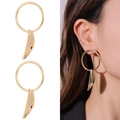 Dettaglio e modella che indossa orecchini a cerchio dorati con pendenti in metallo fluido - Stile a Cerchio con Pendente a Foglia Intrecciata Aerodinamico (NXE05223-1)