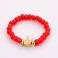 Detail shot of a handmade red bead ring featuring a golden crown centerpiece charm - One Size / Red Crown Style (NXR01552)