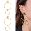 Dettaglio di orecchini a doppio cerchio geometrico placcati in oro su modella con sfondo bianco - Stile a Doppio Anello Intrecciato con Fibbia Semicircolare Filettata (NXE05213)