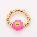 Detail of pink flower charm with yellow smiley face on golden beaded elastic ring - One Size / Pink Sun Flower Smiley Style (NXR01557)