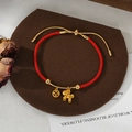 Red braided rope bracelet with golden zodiac charm and red gem pendant detail - Hollow Coin Gemstone Style (SL90332)