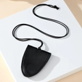 Detail of black pebbled leather key clochette with neck strap on a white stone base - 7.7x6cm / Black