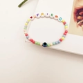 Detail van kleurrijke DIY-kralenarmband met FRIEND-letters en blauwe Evil Eye kraal - FRIEND Letters Hart Stijl