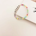 Detail van kleurrijke kralenarmband met Sisters-letterkralen en pastelkleurige kralen - SISTERS Letters Stijl