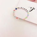 Détail du bracelet en perles colorées avec lettrage Sisters et breloque œil bleu - Style Lettres SISTERS Mauvais Œil