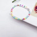 Detail van kleurrijke kralenarmband met BEST-letters en een zwart smiley-gezichtpictogram - BEST Letters Smiley Stijl