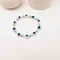 Elastisches Evil Eye Armband mit weißen Perlen und silbernen Metallperlen in Blau-Weiß - Porzellanweiß