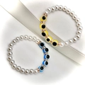 Makroaufnahme von Barockperlen-Armband mit gelben und blauen Evil-Eye-Anhängern und Kristallen - Seeblau