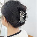 Silver metallic hair claw clip with irregular lava texture shown on model hair - Wxf07201-1