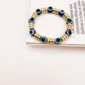 Detailansicht eines elastischen Evil-Eye-Perlenarmbands mit blauen Perlen und Gold - Blau