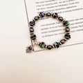 Detail of beaded bracelet with black striped beads, Hamsa Hand and evil eye charm - Black Striped With Hamsa (Style 1)