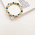 Détail du bracelet perlé œil grec avec perles blanches et anneaux intercalaires dorés - Blanc Porcelaine