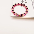 Turkish pink evil eye beaded bracelet with gold cylindrical spacers on white magazine - Rose Red