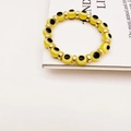 Detail of yellow translucent beads featuring the evil eye symbol and gold spacers - Yellow