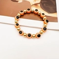 Detail of blue eye elastic beaded bracelet with vibrant orange beads and golden spacers - Orange Red
