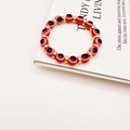 Detailed macro view of red evil eye beads and golden metal spacers on elastic bracelet - Red