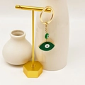 Macro detail of a gold-plated evil eye keychain with green enamel on a golden stand - Green Style 3