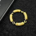 Golden acrylic bead evil eye bracelet with amber-style resin tubes on black background - Yellow