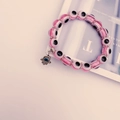 Ροζ βραχιόλι με χάντρες Evil Eye και μενταγιόν Hamsa Hand σε φόντο περιοδικού - Ροζ