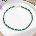 Detail van kleurrijke kralenketting met groene malachietcilinders en gouden afstandhouders - Malachietgroen (Stijl A)