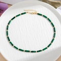Detailweergave van groene malachiet kralen en gouden spacers met een karabijnsluiting - Groene Cilindrische Stijl (Model C)