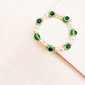 Vista de detalle de perlas blancas y cuentas de ojo turco verde en pulsera bohemia - Verde oscuro