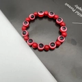 Macro shot of red natural stone beads and evil eye charms on a beaded elastic bracelet - 10mm / Red (1)