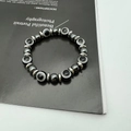 Detailed close-up of hematite bead bracelet with blue Evil Eye and silver spacers - Gray