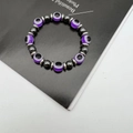 Detail view of hematite beads and purple Evil Eye charms on an elastic bracelet - Purple