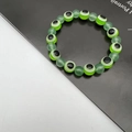 Detailed close-up of green crystal beads and evil eye charms on an elastic bracelet - 10mm / Grass Green (4)