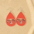 Macro shot of red faux leather teardrop earrings featuring ethnic thunderbird patterns - Red Thunderbird Ethnic Style
