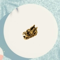 Macro detail of vintage gold-plated dragon head bead with intricate traditional carvings - Antique Gold