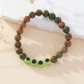 Detail of handmade evil eye beaded bracelet with unakite stones on stone background - Unakite Stone