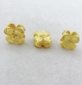 Macro detail of three gold-plated clover beads with matte texture for DIY jewelry making - Four-Leaf Clover Style