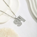 Detail of silver Figaro chain necklace with a rhinestone number 91 pendant on white props - Pave White Rhinestone Style / Silver